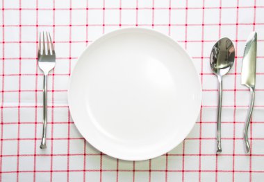 Beyaz bıçak tabak ve çatal kaşık kırmızı işaretli masa örtüsü