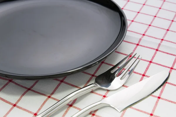 Plate fork and knife on red napkin and wine glasses — Stock Photo, Image