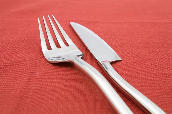 Garfo e faca na toalha de mesa vermelha — Fotografia de Stock