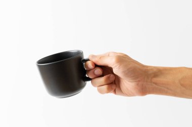 Beyaz arka planda siyah kahve tutan el.