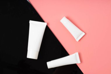 Beyaz gerçekçi kozmetik tüpleri arkada ve pembe