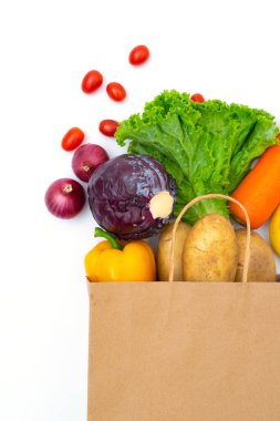 Beyaz arka planda kağıt torbalarda taze sebzeler.