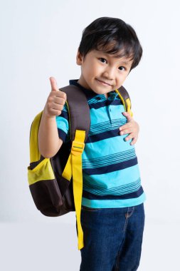 Mutlu gülümseyen küçük çocuk okula geri dönüyor.