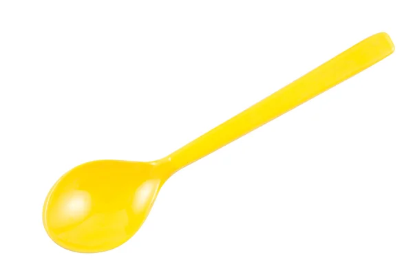 Жовта пластикова ложка на білому фоні — стокове фото