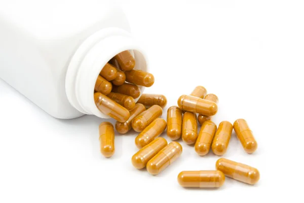 Herb capsules spilling out of a bottle — Stock Photo, Image