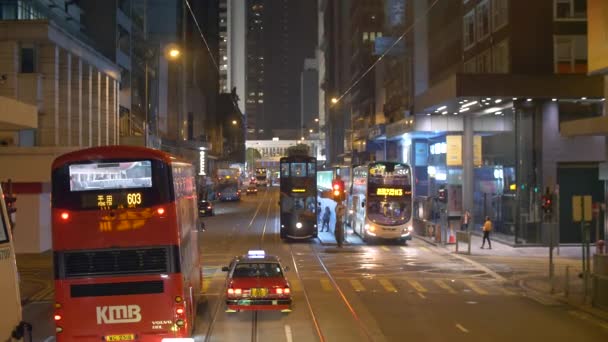 Kırmızı çift katlı otobüsler ve arabalar Geceleyin Hong Kong sokaklarından geçiyor. — Stok video