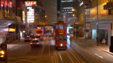 Kırmızı çift katlı bir otobüs Hong Kong sokaklarında ilerlemeye devam ediyor.