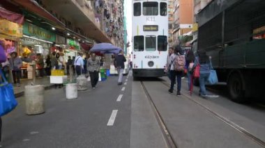 HONG KONG - 23 HAZİRAN 2020: kalabalık bir caddede arka planda bir otobüsle yürüyen insanlar