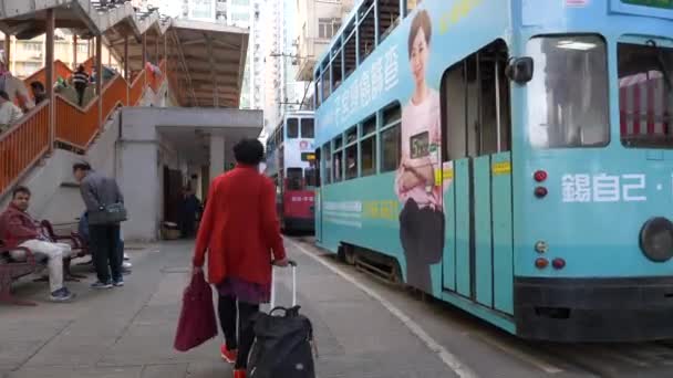 Hong Kong - 23 de enero de 2020: Un autobús azul de dos pisos y gente que pasa por una calle llena de gente — Vídeo de stock