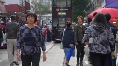 Hong Kong - 23 Ocak 2020: Kalabalık bir caddede yürüyen Çinliler ve arka planda siyah bir otobüs