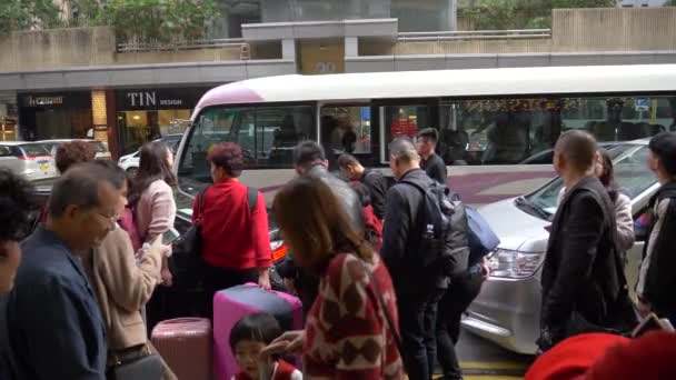 Hong Kong - 23 de enero de 2020: Los chinos caminan por una calle animada y un minibús en el fondo — Vídeo de stock