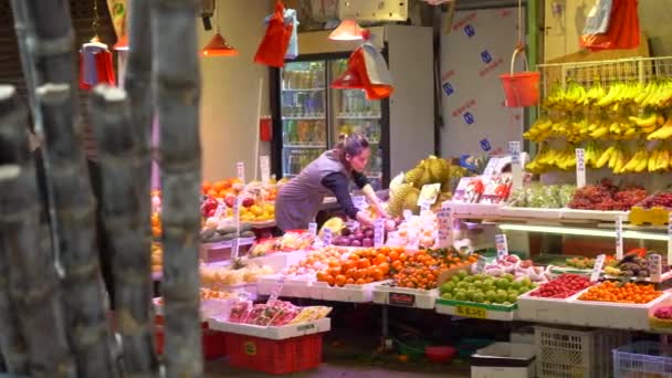 Hong Kong - 23 de janeiro de 2020: chineses passando pelo balcão de frutas no mercado de alimentos — Vídeo de Stock