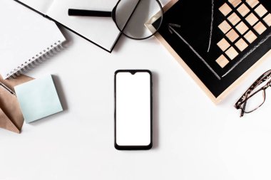 İş düzlüğü beyaz arka planda yatıyordu. Akıllı telefon modeli, zarf, defter, kredi kartı, karatahta, gözlük. İş istatistikleri. Kariyer, para, başarı konsepti. İşyeri organizasyonu.