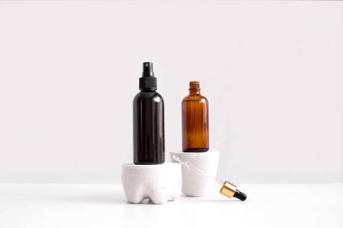 Serum, yağ, asit, losyon, açık kahverengi damlacık bardağında pippete ve sprey şişesiyle birlikte beton kaidenin yan tarafında fotokopi alanı ile birlikte. Spa ürünleri. Organik, doğal kozmetik. Güzellik, cilt bakımı
