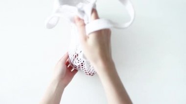 Eller pamuktan örülmüş örgü çantasını beyaz masanın üzerine kahverengi yumurtalarla örüyor. Üst manzara çevre dostu, yeniden kullanılabilir ip torbası. Sıfır atık paskalya. Minimalizm tarzı Paskalya Günü