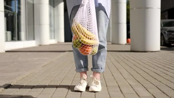 Mujer Jeans Sosteniendo Sacudiendo Sacudiendo Bolsa Malla Blanca Con Frutas — Vídeos de Stock
