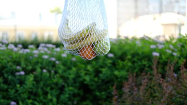 Bolsa Malla Blanca Con Frutas Girando Sobre Fondo Calle Eco — Vídeos de Stock