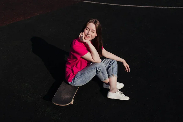 Young Woman Pink Shirt Closed Eyes Sitting Skateboard Summer Activity — ストック写真