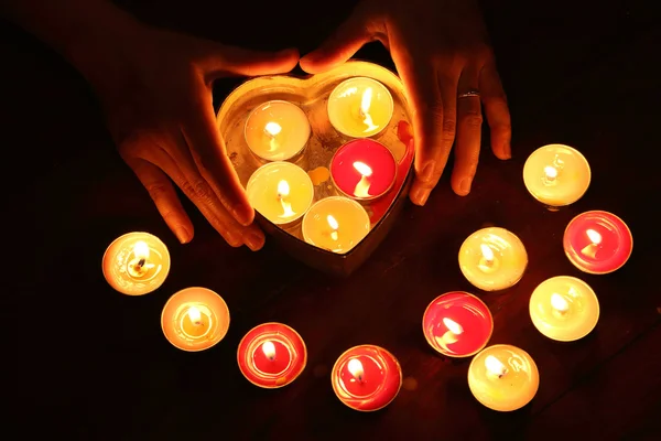 Vela ardente forma de coração em mãos femininas — Fotografia de Stock