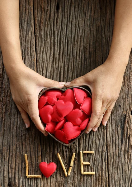 Mulheres mãos segurando coração vermelho em forma — Fotografia de Stock