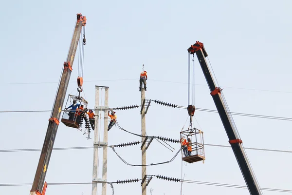 Electricista trabajando en altura conectando un cable de alto voltaje . —  Fotos de Stock