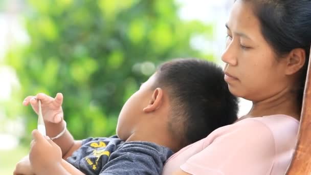 Mother and son sitting on rocking chair. — Stock Video