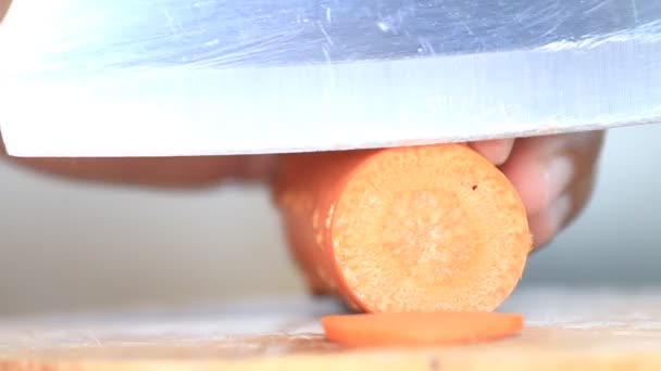 Ręce do krojenia marchewki na pokładzie drewnianym, z bliska klip Hd. — Wideo stockowe