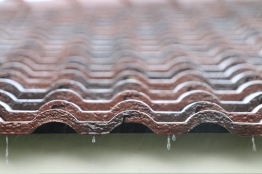 Kahverengi tuğla çatı üzerine düşen yağmur damlası