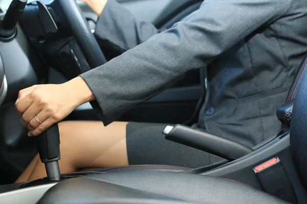 Mujer de negocios cambiando la palanca de cambios para conducir un coche —  Fotos de Stock