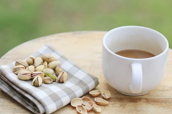 Pistachio nut and white coffee cup. — Stock Photo, Image