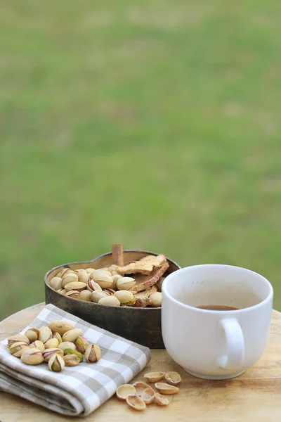Pistachio nut and white coffee cup. — Stock Photo, Image