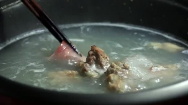 Японське продовольство, нарізаний свинини сябу-сябу покласти до кипіння води горщик. — стокове відео