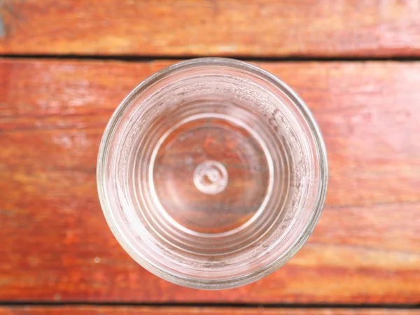 Dricka vatten i glas, trä bakgrund. Visa från ovan. — Stockfoto