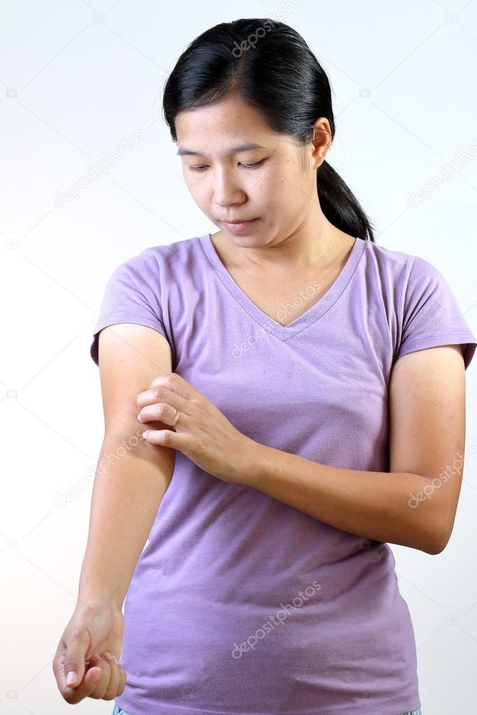 Asian Thai woman scratching her arm.