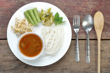 Tay ahşap masa üzerinde sebzeli erişte pirinç.