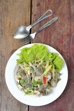 ahşap masa üzerinde mavi yengeç ile baharatlı mango salatası.