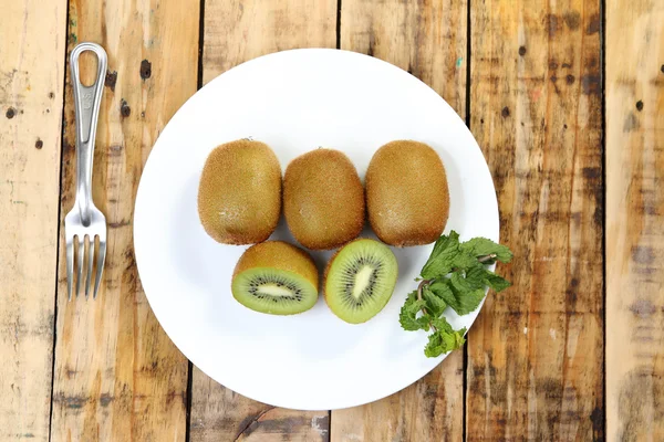 Rebanada de fruta Kiwi sobre fondo de madera de tablón . —  Fotos de Stock