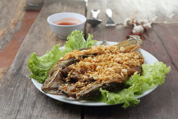 Fried Snapper sarımsak ve biber ahşap masa üzerinde. — Stok fotoğraf