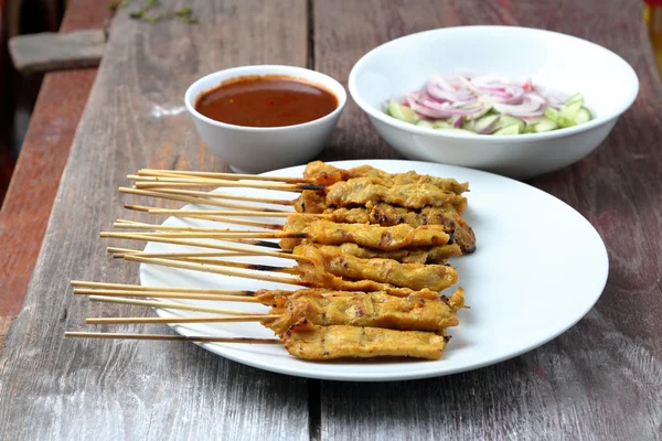 Satay wieprzowina z sosem orzechowym, stół z drewna tło. — Zdjęcie stockowe