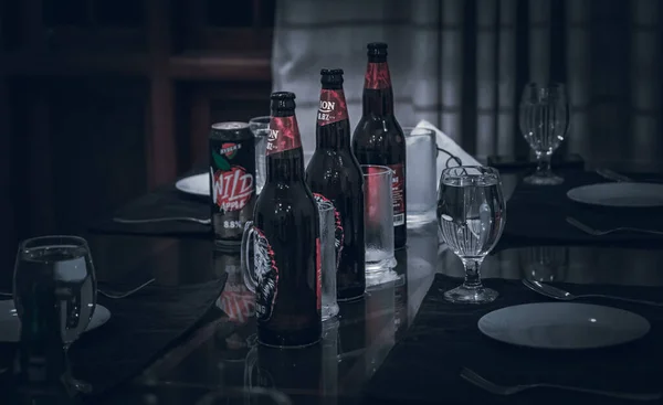 small gathering with beers and plates on the table night lights dark photograph