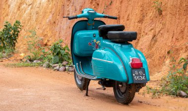 Galle, Sri Lanka - 06 21 2020: Eski model mobilet motosikleti kil duvara karşı sergileniyor. Açık mavi renkli ve iki koltuklu, depo için kompartımanlar, ön tarafta yuvarlak far. Arkadan görünüm.