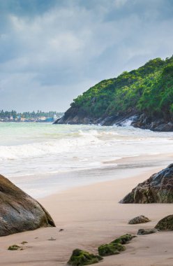 Güzel sahil manzarası dağın dikey görüntüsü ve kasvetli bulutlar, altın kumlar ve kıyıdaki kaya oluşumu..