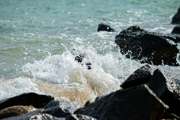 海浪冲击着海滩上的岩石 清澈的海水冲破成了白色泡沫 — 图库照片