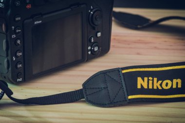 Sri Lanka - 02 17 2021: Modern profesyonel DSLR gövde ve boyun tuzağı Nikon markası tahta bir masaya gömülü, Nikon D850 yakın plan fotoğraf.