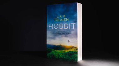 Galle, Sri Lanka - 04 07 2021: The Hobbit by J R R. Tolkien, famous Lord of the ring prelude novel standları. Çocuklar için fantezi kurgu romanı. Okumak insanı tam bir erkek yapar. Karanlıkta ışık.