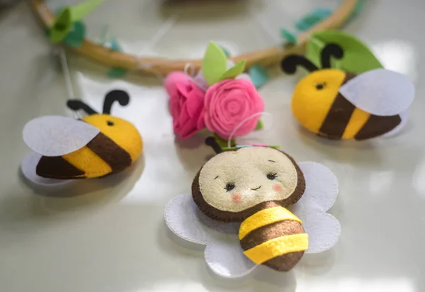 Cute bees and flowers handmade from felt material and plush with paddings. close up cot mobile hangings.