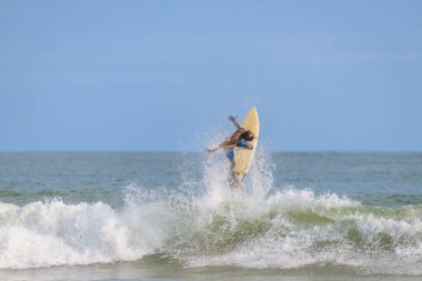 Weligama, Sri Lanka - 05: 20 2023: Bir sörfçü Weligama, Sri Lanka 'daki güçlü bir dalganın üzerinde etkileyici bir hava manevrası gerçekleştirir.