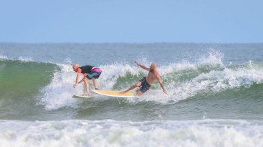 Weligama, Sri Lanka - 05: 20 2023: İki sörfçü aynı dalgayı sürerken çarpışıyor, bir sörfçü sörf tahtasında dengesini kaybederken düşüyor