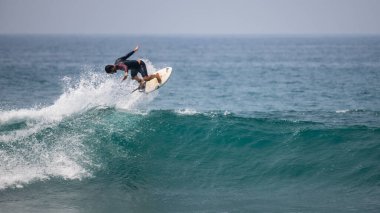 Midigama, Sri Lanka - 03 05 2024: Profesyonel sörfçü mükemmel bir hava uyguluyor. Turkuaz bir dalganın üzerinde havadan manevra yapar, etkileyici bir denge ve güç sergiler - orta-hava dizisi-2-02