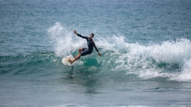 Midigama, Sri Lanka - 03 05: 2024: Erkek sörfçü temiz bir dalgada kesintiye uğruyor, vücudu düşük ve dengeli, tek kolu kontrollü, etrafını sprey kapladıkça oyuyor. Sekans-6-01
